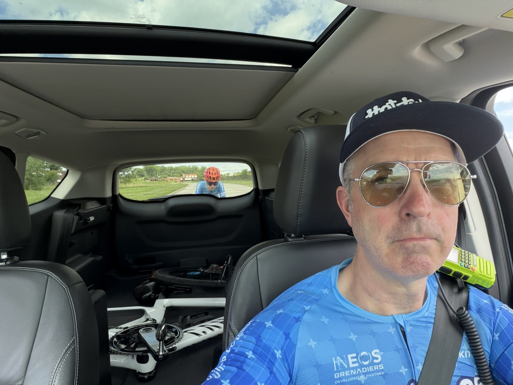David Sommerville, cycling coach and Director Sportif, in a support car with a rider visible through the rear window