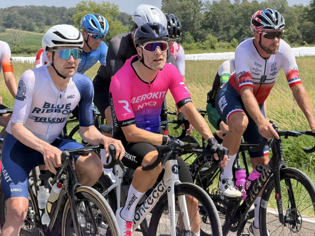 Cyclists riding together with a rider in bright pink AEROKIT kit